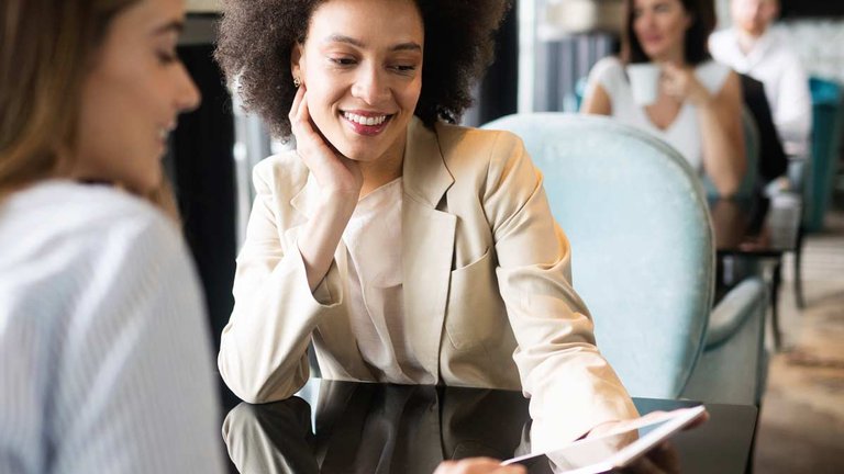 Two women sharing info on an iPad