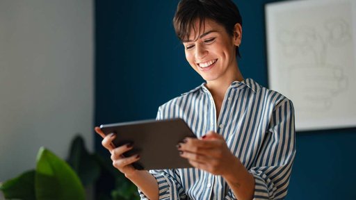 Smiling woman looking at iPad in office